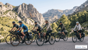 Cicloturismo para principiantes: grupo mixto de ciclistas y usuarios de bicicleta eléctrica rodando juntos por carretera de montaña en la Costa Blanca Norte